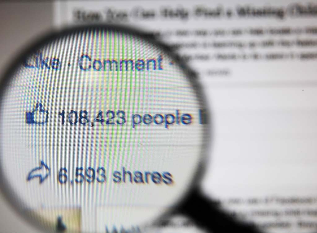 user generated content benefits - magnifying glass on lots of Facebook shares and likes