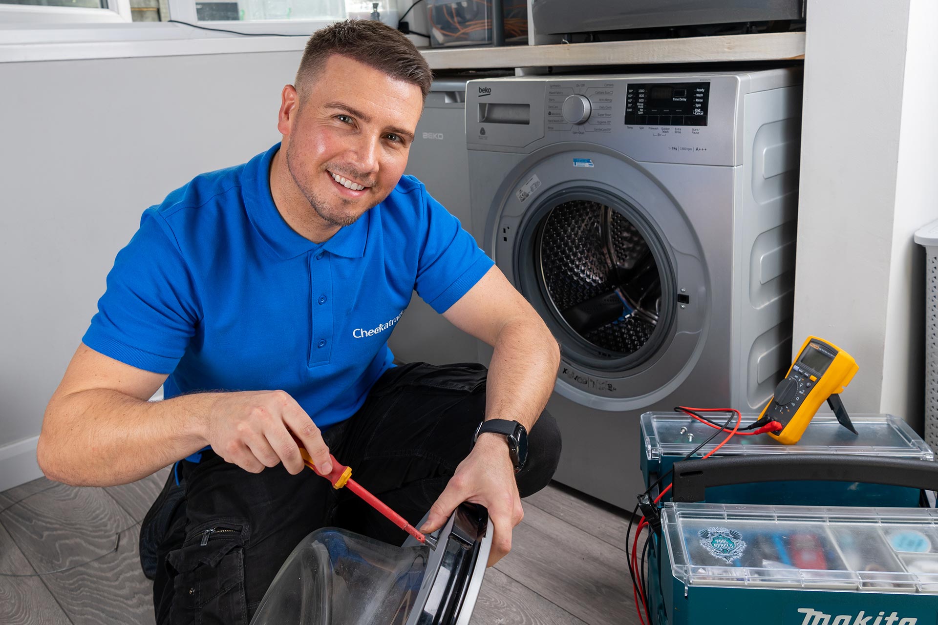 Tradesperson servicing a washing machine