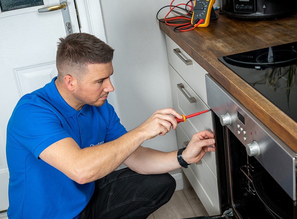 Electrician servicing an electric cooker