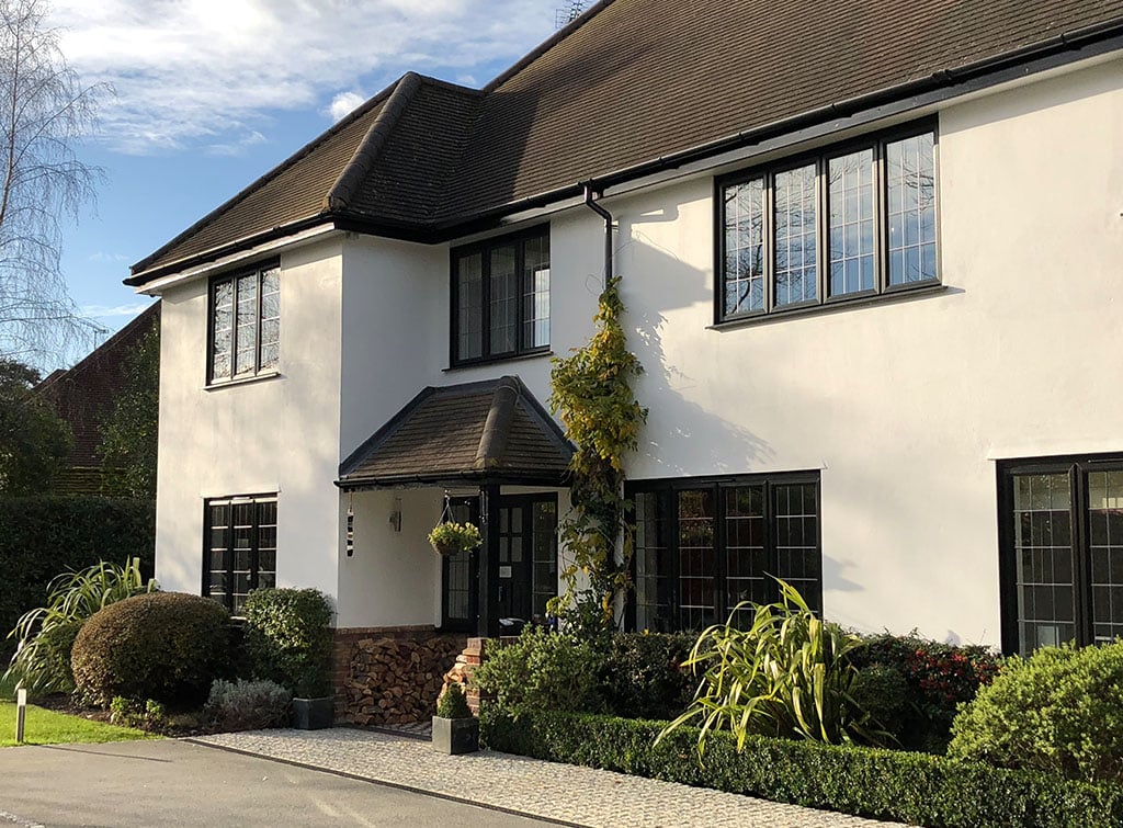 Black framed casement windows on a tudor style home