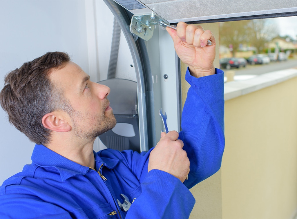 Garage door installer fixing a broken garage door