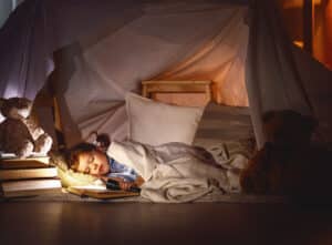 Child asleep in a pillow fort for Checkatrade blog: kids bedroom ideas