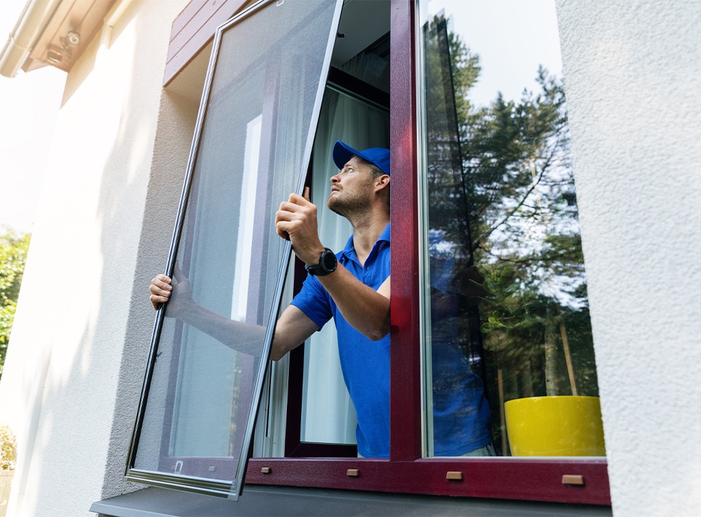 man replacing window screen