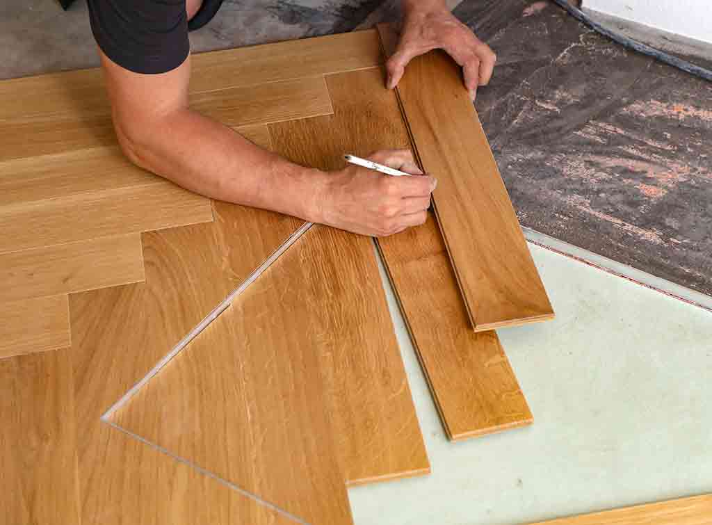Herringbone flooring being laid by a floor fitter