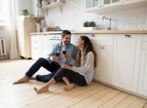 Couple sat on wood kitchen flooring
